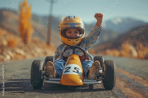 A determined young racer celebrates a victory with arms raised, wearing a yellow helmet and racer attire