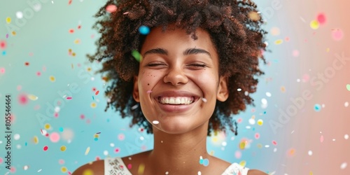 Joyful young biracial woman celebrating with colorful confetti, expressing happiness in festive atmosphere, vibrant moments captured in lively photograph.
