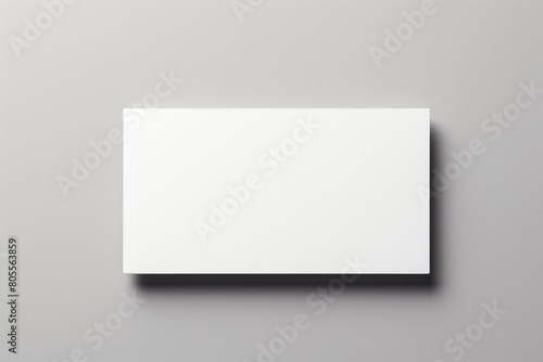 A simple blank white rectangular box or panel placed horizontally on a gray marble surface, casting a soft shadow beneath.