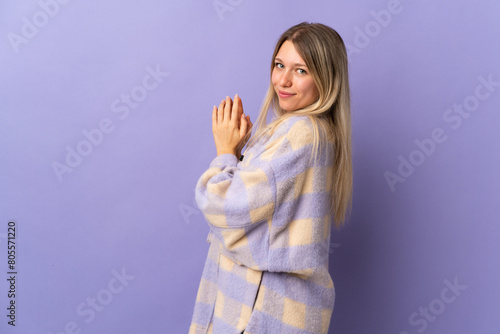 Young blonde woman isolated on purple background scheming something