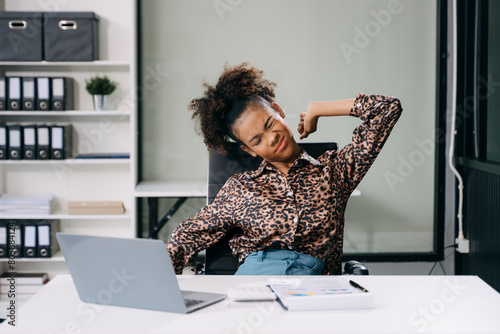 Overworked young businesswoman office worker suffering from neck pain after had a long day at her office desk