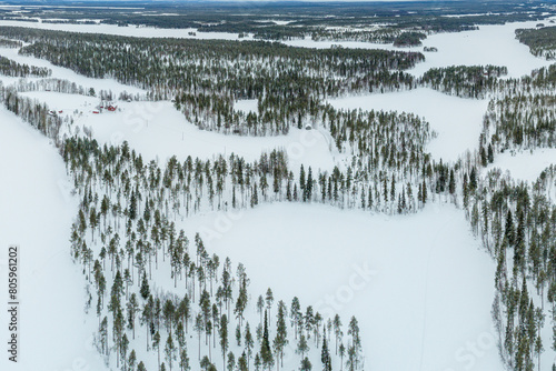 Aerial view over taiga landscape with snow covered boreal forest and fields in south Lapland, Finland 