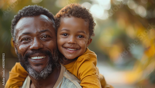 A afro american dad and his child , they are happy and smiling at the park on a sunny day. Father day concept