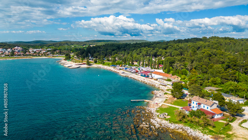 In the vicinity of Rovinj and Camp Valalta in Istria, Croatia, the landscape is characterized by scenic fields, bicycle roads, and lush greenery captured by drone