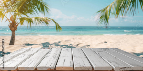 a wooden white table at the sandy beach with palms on the background for minimalistic summer idea banner