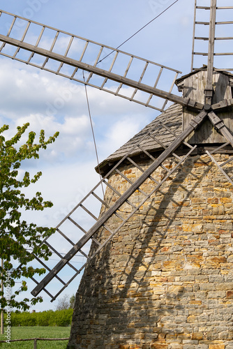 Old Dutch windmill. Built in 1880-1885 in Szwarszowice. Standing on a green meadow with blue sky and clouds. Stary holenderski wiatrak. Zbudowany w latach 1880-1885 w Szwarszowicach. Stojąc na zielone