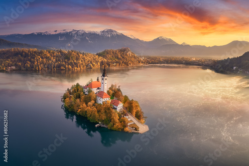 Aerial view of a colourful autumn sunrise over Lake Bled with snow-capped Julian Alps and Bled Castle in the background, Upper Carniola, Triglav National Park, Bled, Slovenia