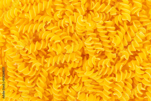 Close up of uncooked yellow Rotini pasta for a background. Ingredient for a delicious italian meal