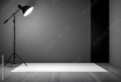 A black and white photo of a studio with a black and white light shining on a white background