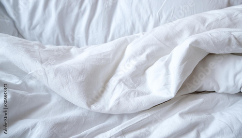 Crumpled sheet. Morning bed. White fabric texture. White minimalistic background.