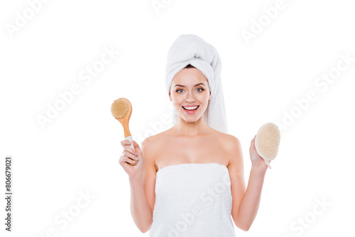 Portrait of positive cheerful woman wrapped in towel with turban on head holding bast and fetlock in hands isolated on white background