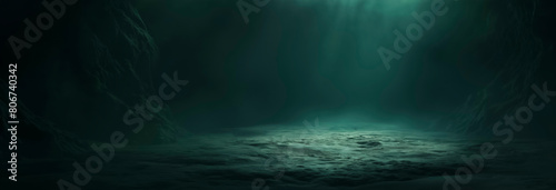 Banner, A dark green, empty room with a faint green light shining from the bottom right corner of frame. floor rough dirt and sand. dim glow of an unknown source kind of underwater rocks or ocean bed