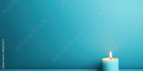 Cyan background with white thin wax candle with a small lit flame for funeral grief death dead sad emotion with copy space texture for display 