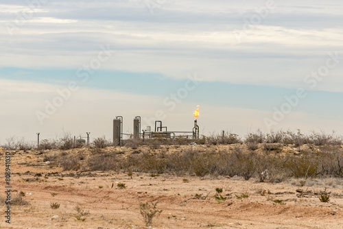 Midland, TX, US-March 31, 2024: Burning excess natural gas at a fracking pad on the Permian Basin.