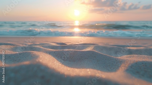  The sun sets over the ocean as sand nearly covers it, with foamy water lapping at the shore