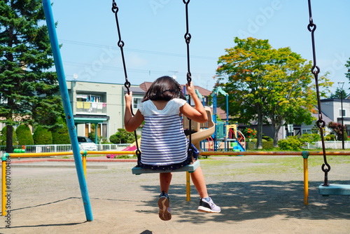 ブランコに乗って遊んでいる小学3年生の女の子