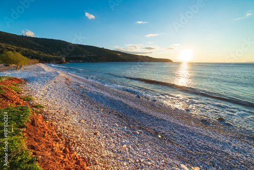 Sunset view beautiful beach and water bay in the greek spectacular coast line. Turquoise blue water unique white pebbles, Greece summer top travel destination Mani peninsula Peloponnese