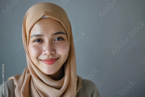 Portrait of young Asian Muslim woman smiling in hijab.
