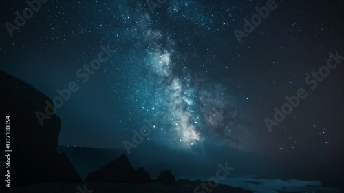 Starry night galaxy night sky full of stars above rocky beach ocean seaside mountain range