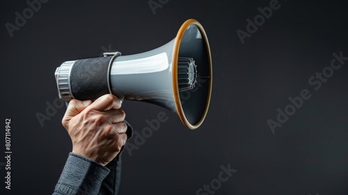 Hand firmly holding a megaphone, close-up with a stark, isolated background, studio lighting casting shadows that highlight determination