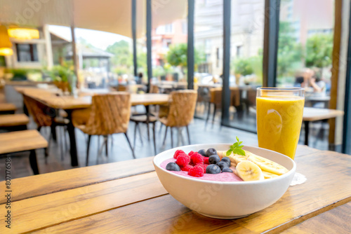 Frühstücksbowl mit Obst, im Hintergrund ein Cafe 