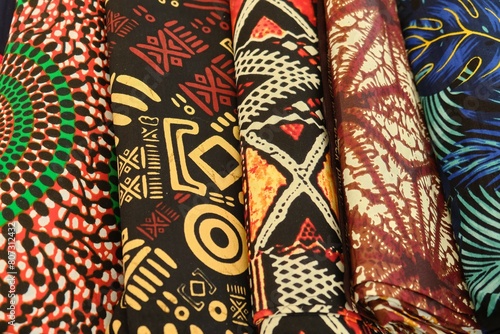Close up of folded multi colour patterned African Ghanaian traditional cotton print cloths