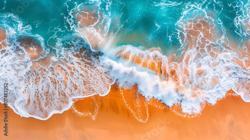 Aerial view of the ocean waves crashing onto an orange sandy beach,