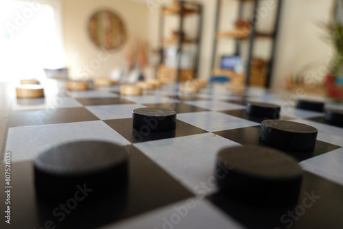 Side view of checkers board game in room with no one.
