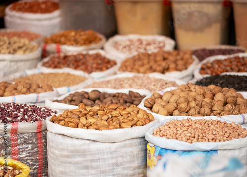 A diverse assortment of nuts and grains attractively displayed in large sacks at a local market, showcasing the variety of healthy bulk food options available...