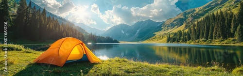 A vibrant orange tent is pitched on the green grass near a tranquil lake on a beautiful summer day