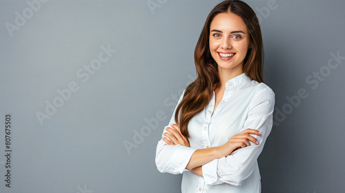 Heureuse jeune femme, d'affaires professionnelle souriante et confiante portant une chemise beige, une femme cadre assez élégante regardant la caméra, debout, les bras croisés isolés sur fond gris