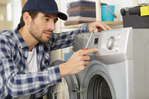 man screwing a washing machine