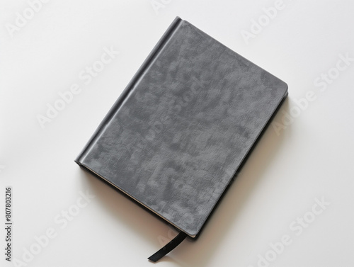 A grey velveteen notebook viewed from above on a white surface.