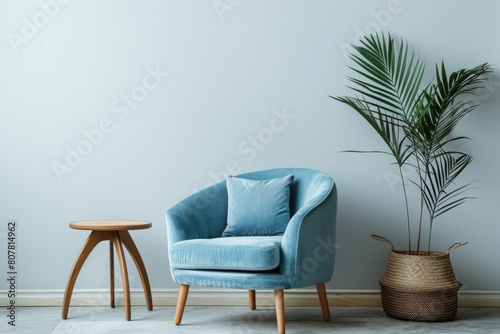 stylish blue armchair with wooden legs and soft cushions stands against the background