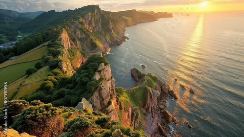 Breathtaking panoramic view of the Valley of Rocks at sunset. Sun-kissed cliffs stand guard over lush green fields, bathed in the vibrant colors of a summer evening.