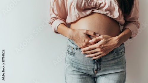 close up of woman's belly with hands on it, white background, stock photo style