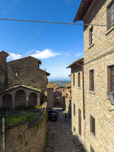urokliwa uliczka miedzy kamiennymi kamienicami, Cortona, Włochy