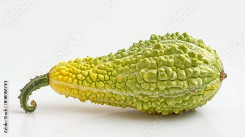 A single bitter melon with its distinctive warty texture, prominently displayed against a white background to highlight its unique shape