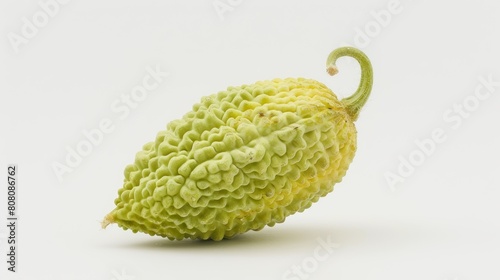 A single bitter melon with its distinctive warty texture, prominently displayed against a white background to highlight its unique shape