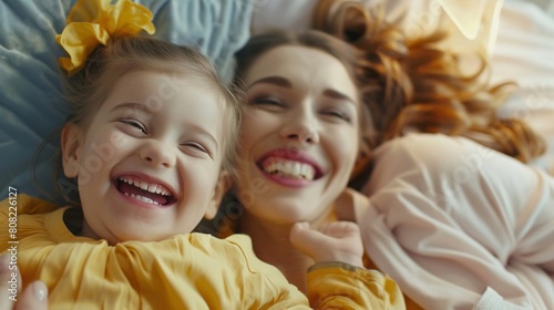 Mamma e figlia sorridono felici sdraiate nel letto