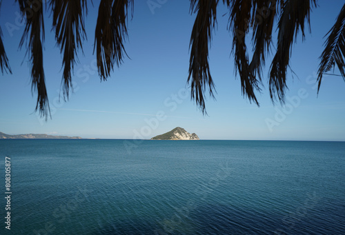 beach and shore of Limni Keriou and Marathonisi island with palm trees leaves