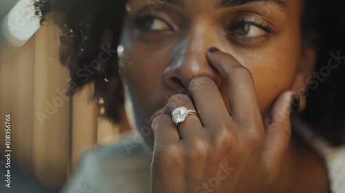 Black woman holds diamond engagement ring. woman contemplating marriage or divorce ~ shot with canon eos rp.