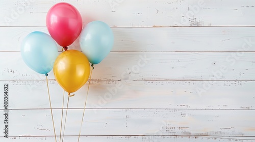 Na zdjęciu przedstawione jest wiele kolorowych balonów, które są przypięte do drewnianego patyka. Balony są przeznaczone dla dzieci, a wszystko odbywa się na białym tle