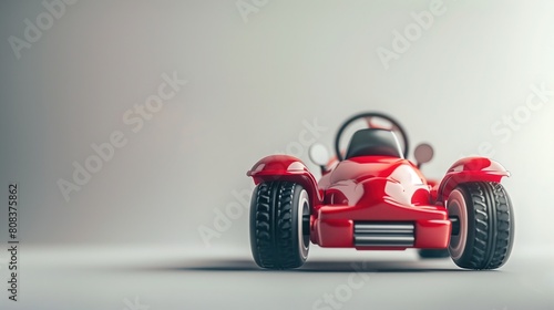Zdjęcie przedstawia czerwony samochód zabawkowy z zamontowaną kierownicą. Samochód jest umieszczony na białym tle, a jego kolorystyka przyciąga uwagę dzieci