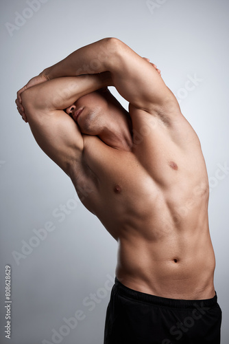 Fitness, stretching and bodybuilder in studio with muscle, abs and strong from training or exercise. Healthy, person and model flexing on background or mockup with wellness from workout in gym