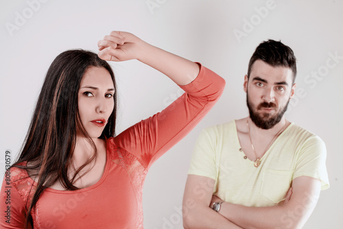 Woman lifts arm, man smells sweat discomfort