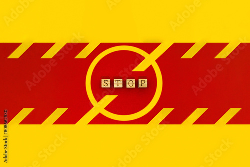 赤いラインにSTOPのアルファベットを並べた黄色い禁止マークの看板