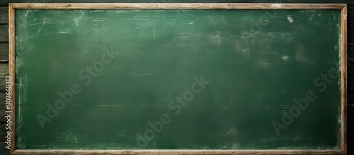 A green chalkboard with a textured surface serves as a school board display The chalk traces have been erased leaving a copy space for adding text or graphic design This backdrop embodies educational