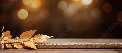 The wooden table background is adorned with a decorative golden leaf providing ample copy space for additional content