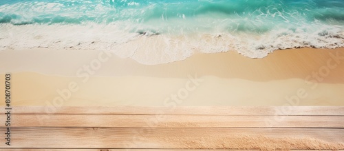 Top view copy space image of the sea against a light wooden background with sand